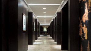A corridor with dark walls, a patterned floor, and recessed lighting. - The Westin Josun Seoul (Seoul)