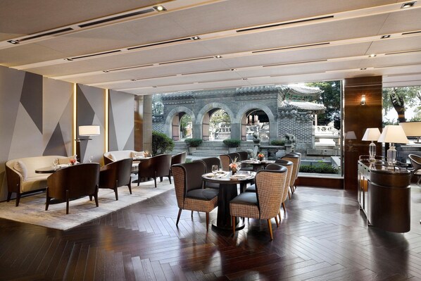 Un comedor moderno con una mesa redonda, sillas y vistas a arquitectura tradicional.