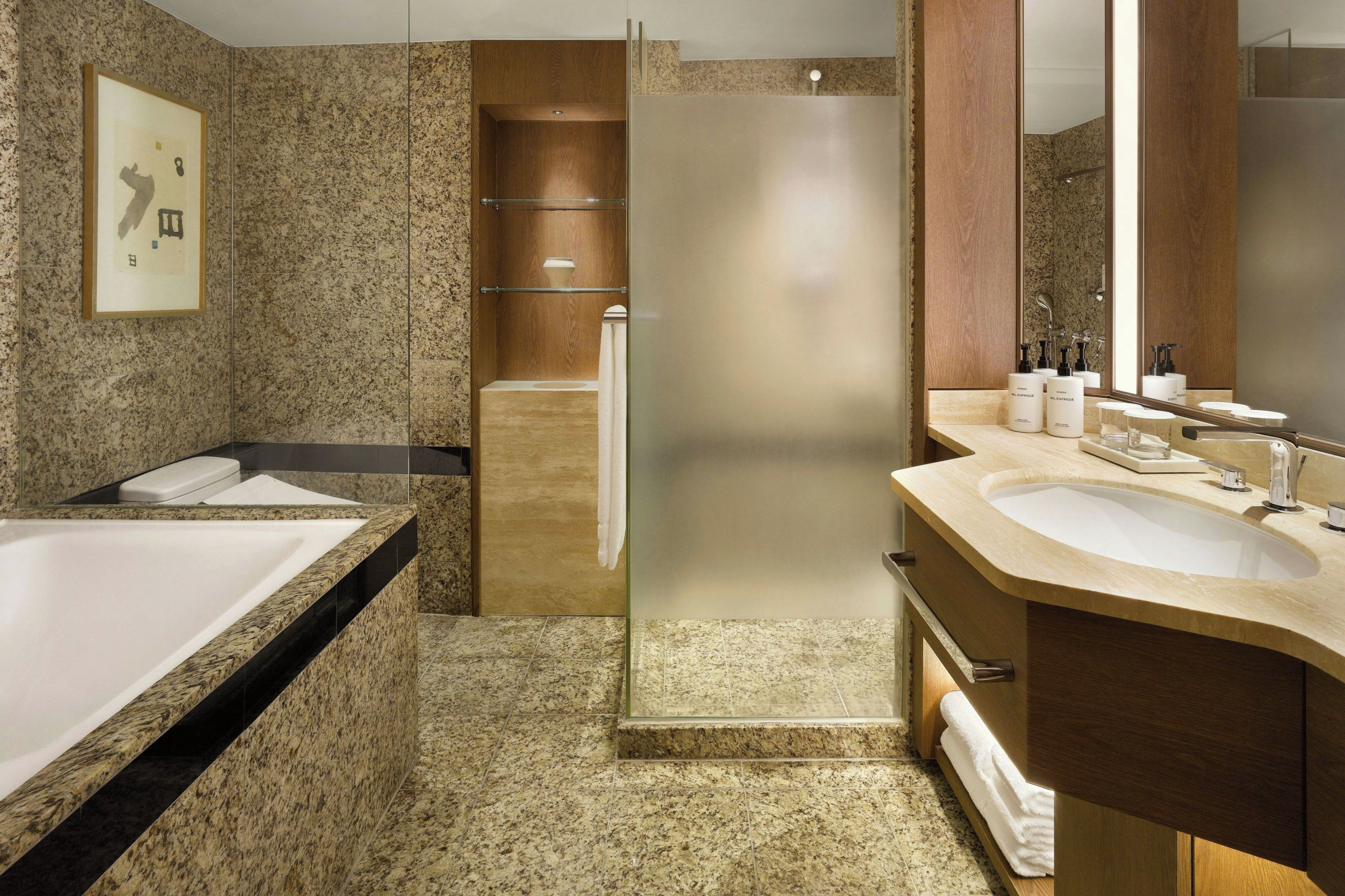 A modern bathroom with a large bathtub, a shower, and a vanity with a mirror.