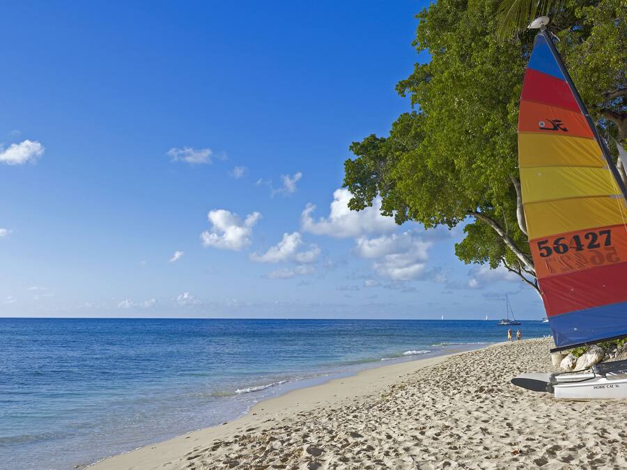 Una playa con un velero y una vela con el número 56427.