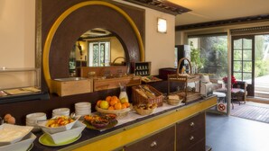 A breakfast buffet with various food items and a mirror above the counter. - Beausejour (Cannes)