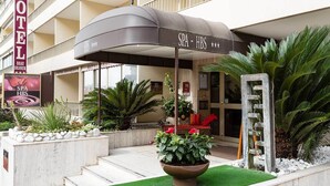 A hotel entrance with a spa and HBS sign, outdoor seating, and a palm tree. - Beausejour (Cannes)