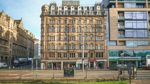 A historic building with multiple stories, featuring a prominent 'Old Waverley' sign, a central entrance, and a modern glass extension. - Old Waverley Hotel (Edinburgh)