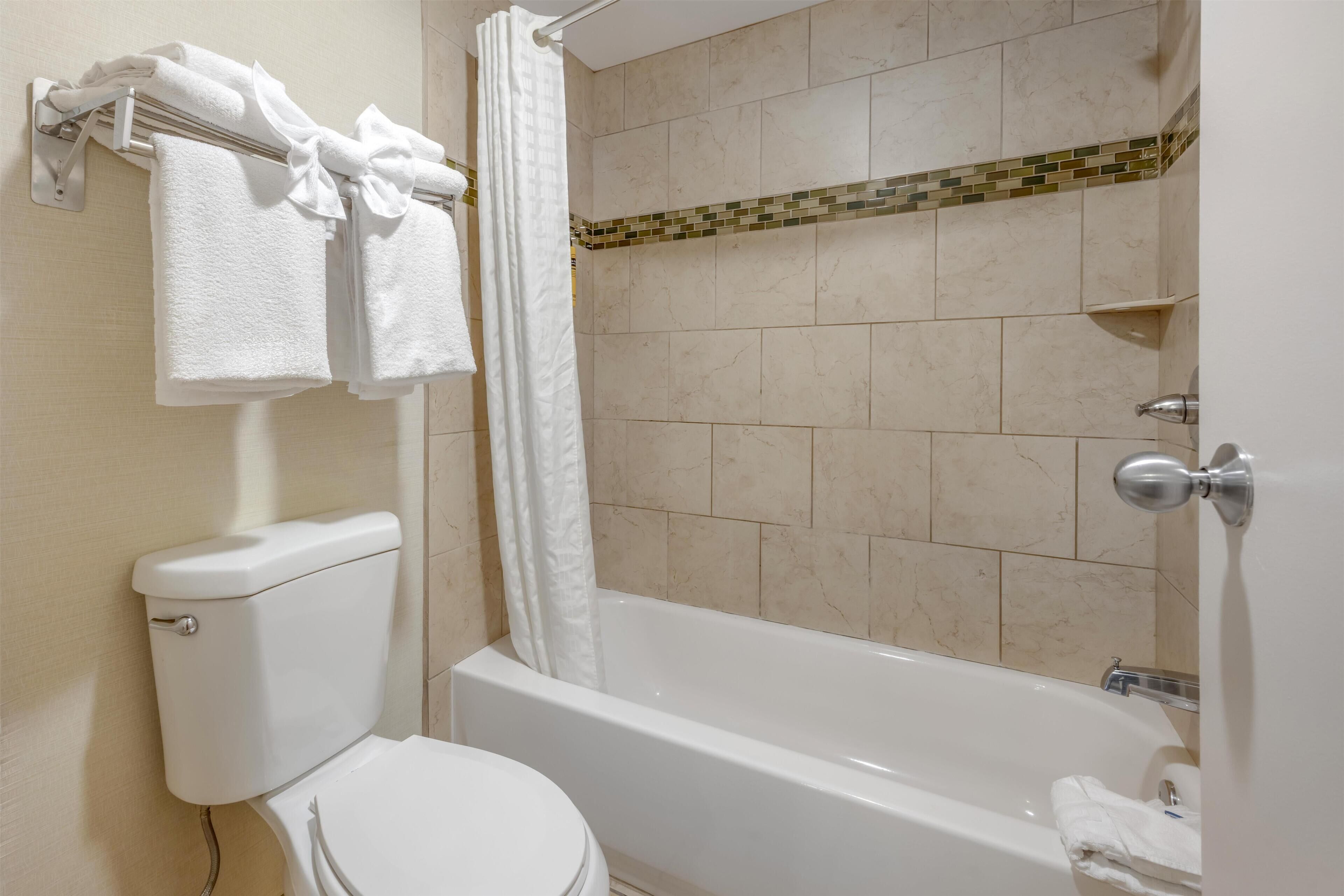 A bathroom with a toilet, bathtub, and towel rack.