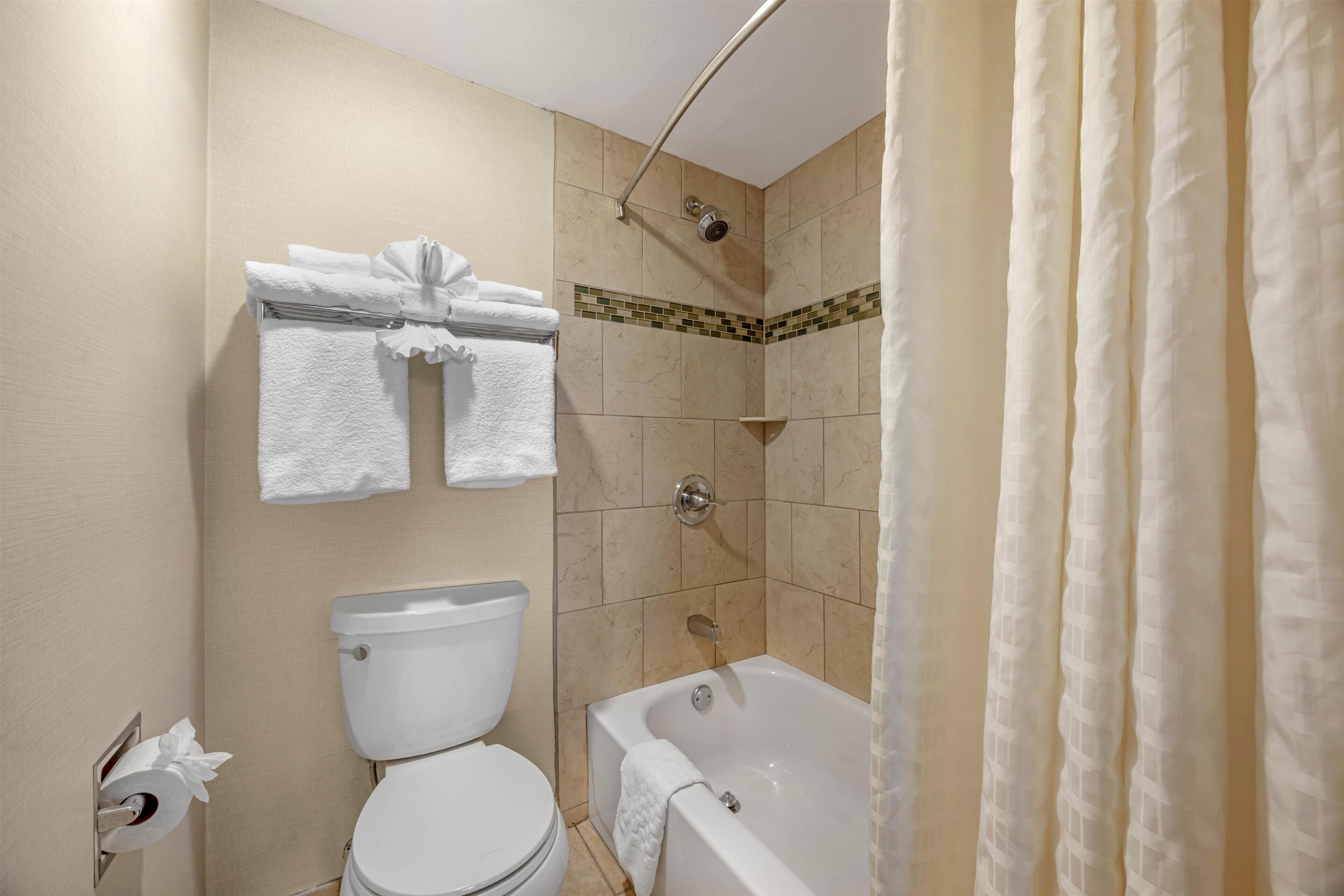 Un baño con inodoro, bañera y ducha.
