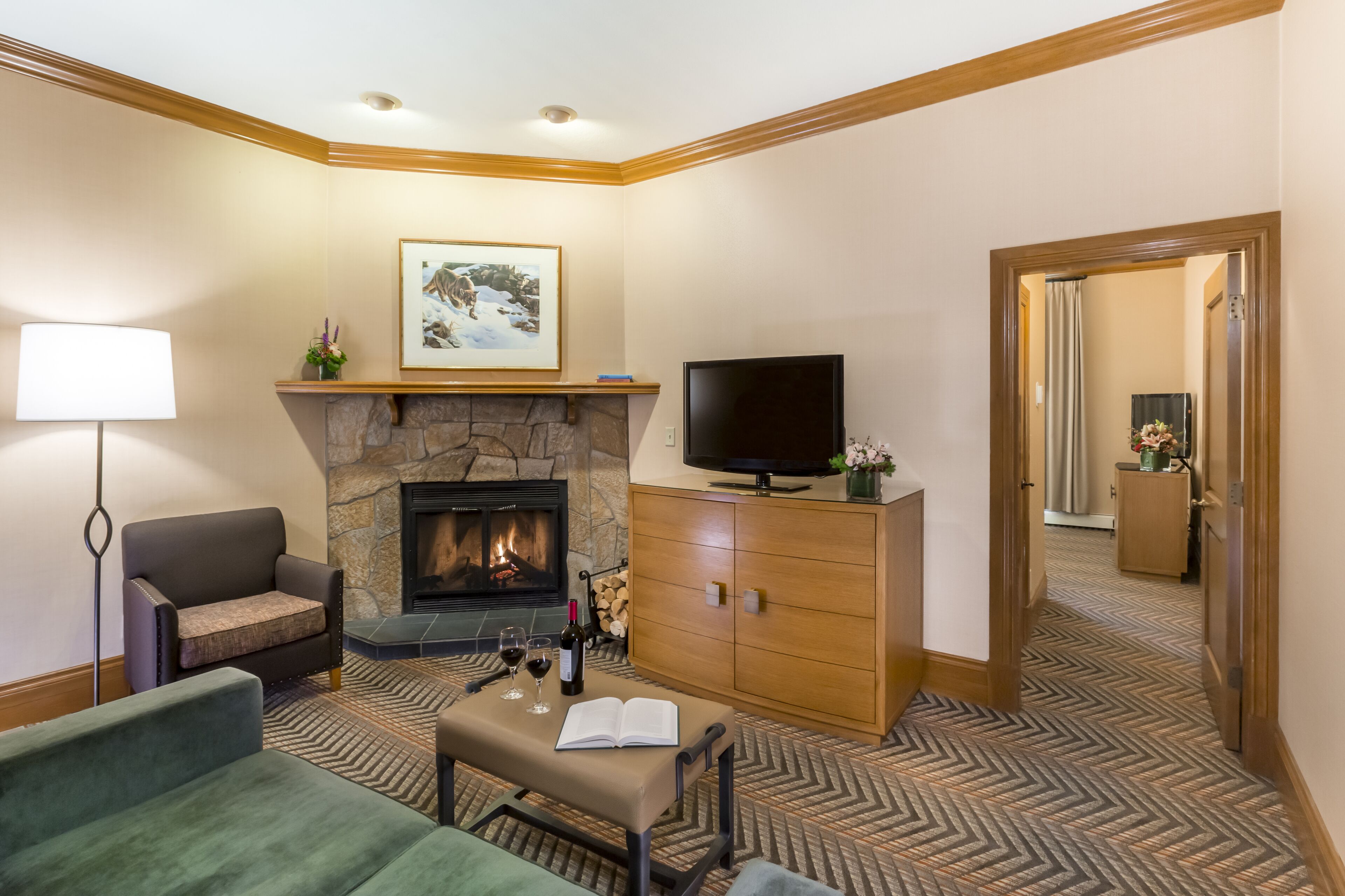 Un salon chaleureux avec une cheminée, un téléviseur et des fauteuils confortables.