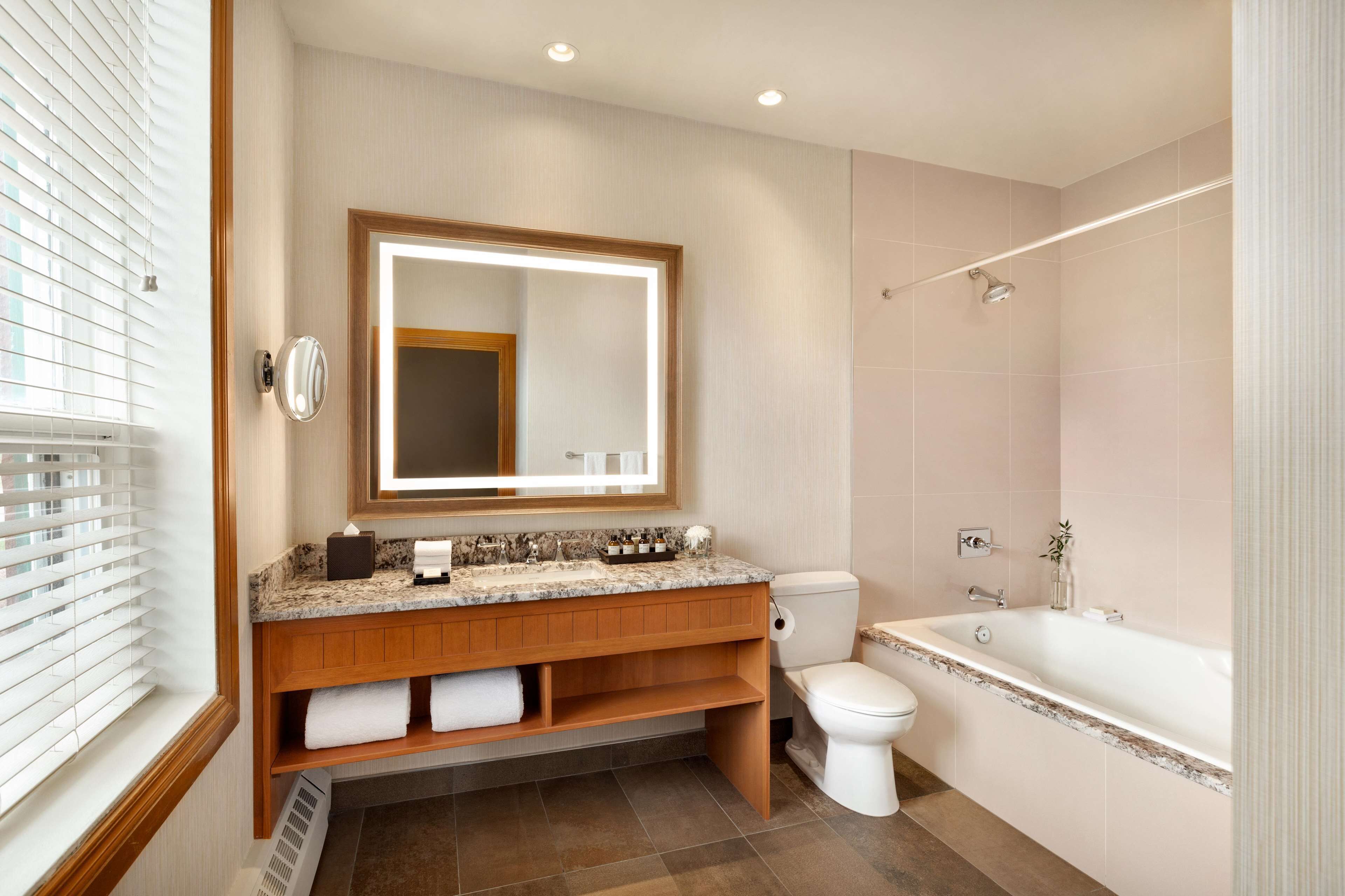 A modern bathroom with a vanity, toilet, and bathtub.
