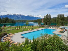 Una piscina al aire libre, sombrillas, sillones reclinables de piscina