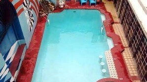 Une piscine rectangulaire bordée de rouge et dotée d’un petit espace circulaire aménagé en jacuzzi.
