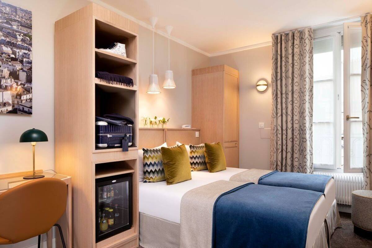 Ein Hotelzimmer mit Bett, Schrank, Schreibtisch, Stuhl und einem Fenster mit Vorhängen.