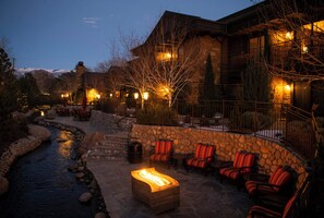 A stone building with outdoor seating and a fire pit. - Wayfinder Bishop (Bishop)