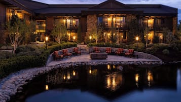 A multi-story building with a landscaped garden and a reflecting pool.