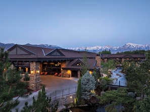 A lodge with a stone facade, a covered entrance, and a view of snow-capped mountains. - Wayfinder Bishop (Bishop)
