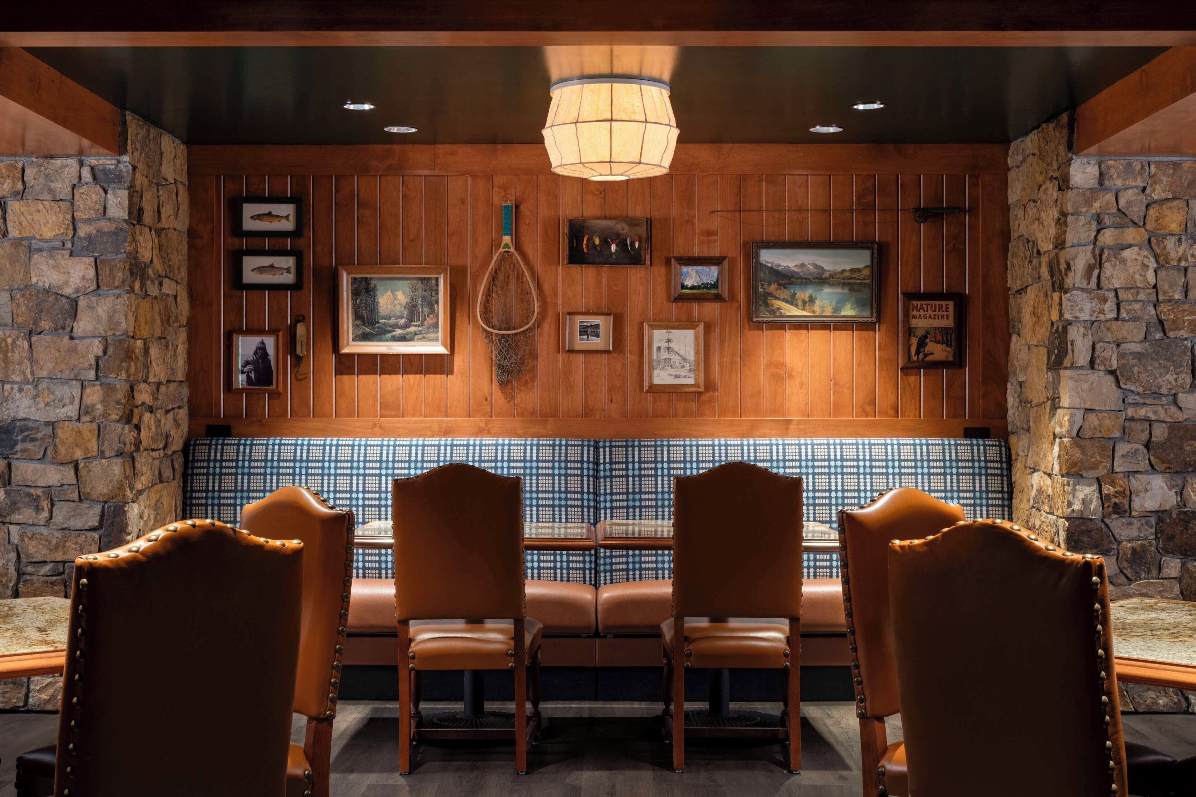 A restaurant with wooden panel walls, stone accents, and a blue patterned backsplash.