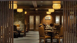A dining area with wooden furniture and hanging lanterns. - Wayfinder Bishop (Bishop)