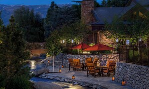 An outdoor patio area with stone walls, a stone pathway, and a view of a mountain range. - Wayfinder Bishop (Bishop)