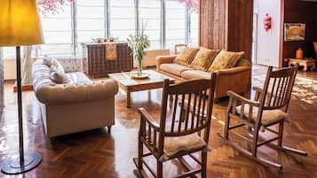 A spacious living room with a sofa, a coffee table, and a rocking chair.