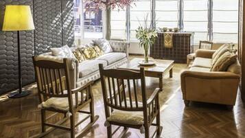 Una habitación con sofá, dos mecedoras, una mesa de centro y chimenea.