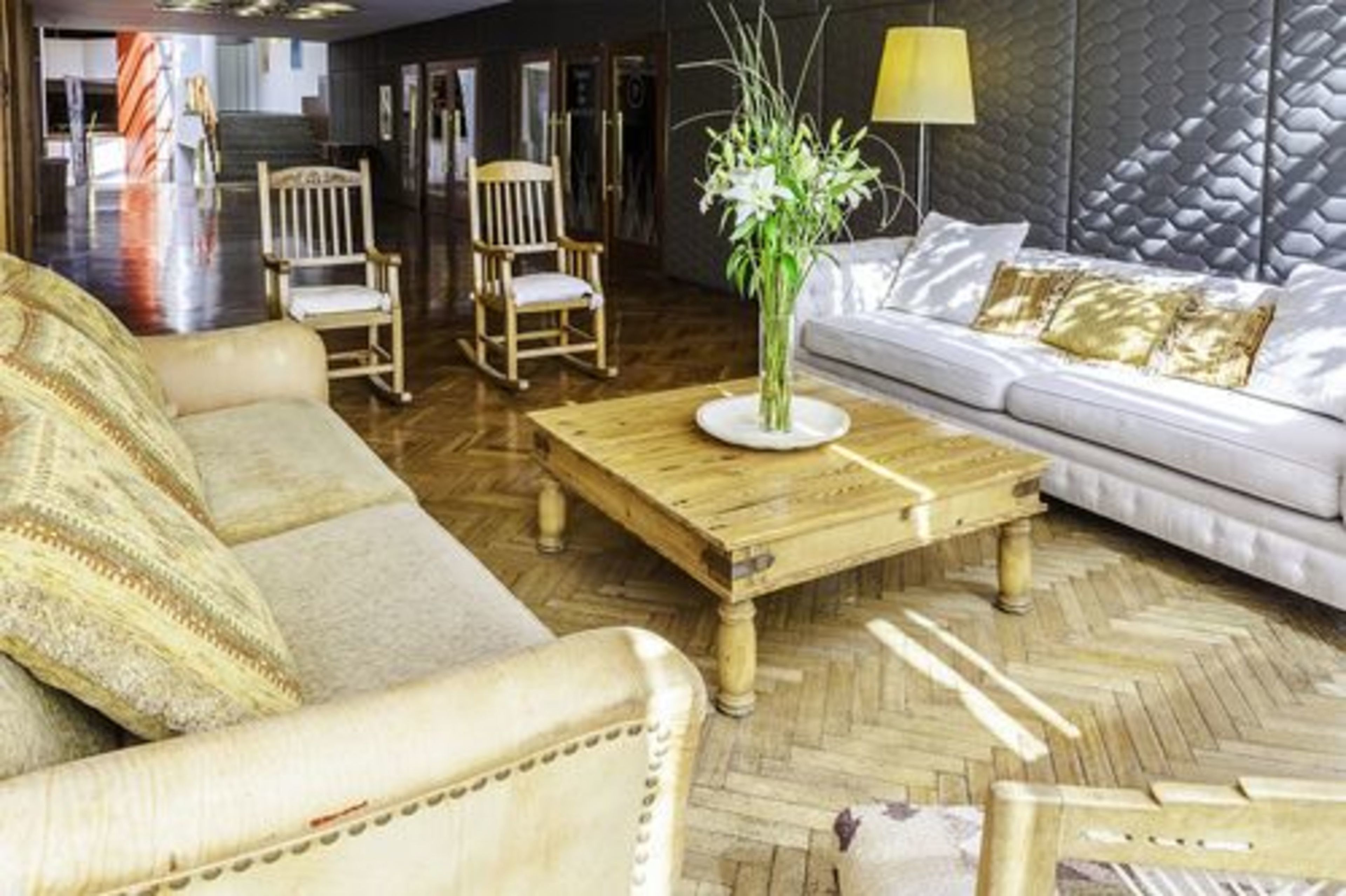 Une pièce comprenant un canapé, une table basse en bois, une chaise et une lampe.
