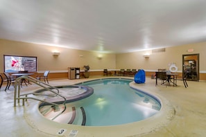 A hotel pool area with a hot tub, lounge chairs, and a pool table. - Skyline Hotel Lake George (Lake George)