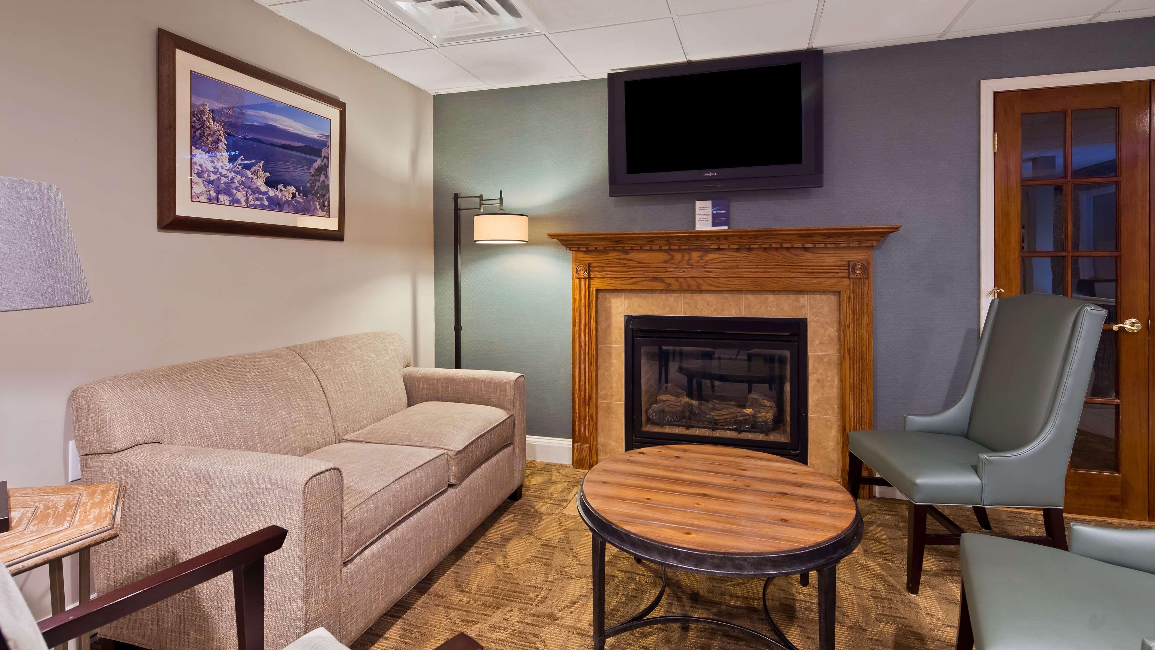 A living room with a sofa, a fireplace, a television, and a door.