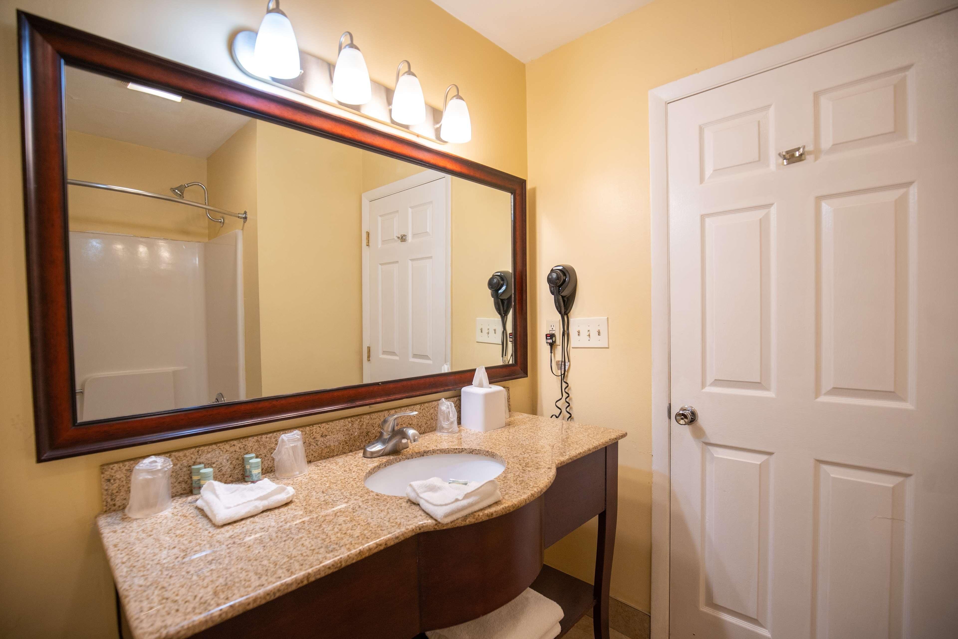 A bathroom with a sink, mirror, towel rack, and hairdryer.