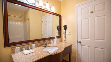 A bathroom with a sink, mirror, towel rack, and hairdryer.