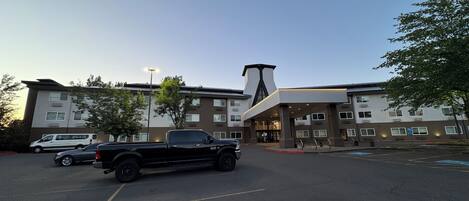 Un hotel de varios pisos con un diseño moderno, que presenta una estructura imponente tipo torre y una entrada cubierta.