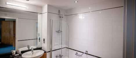 A modern bathroom with a glass-enclosed shower, a sink, and a bathtub.