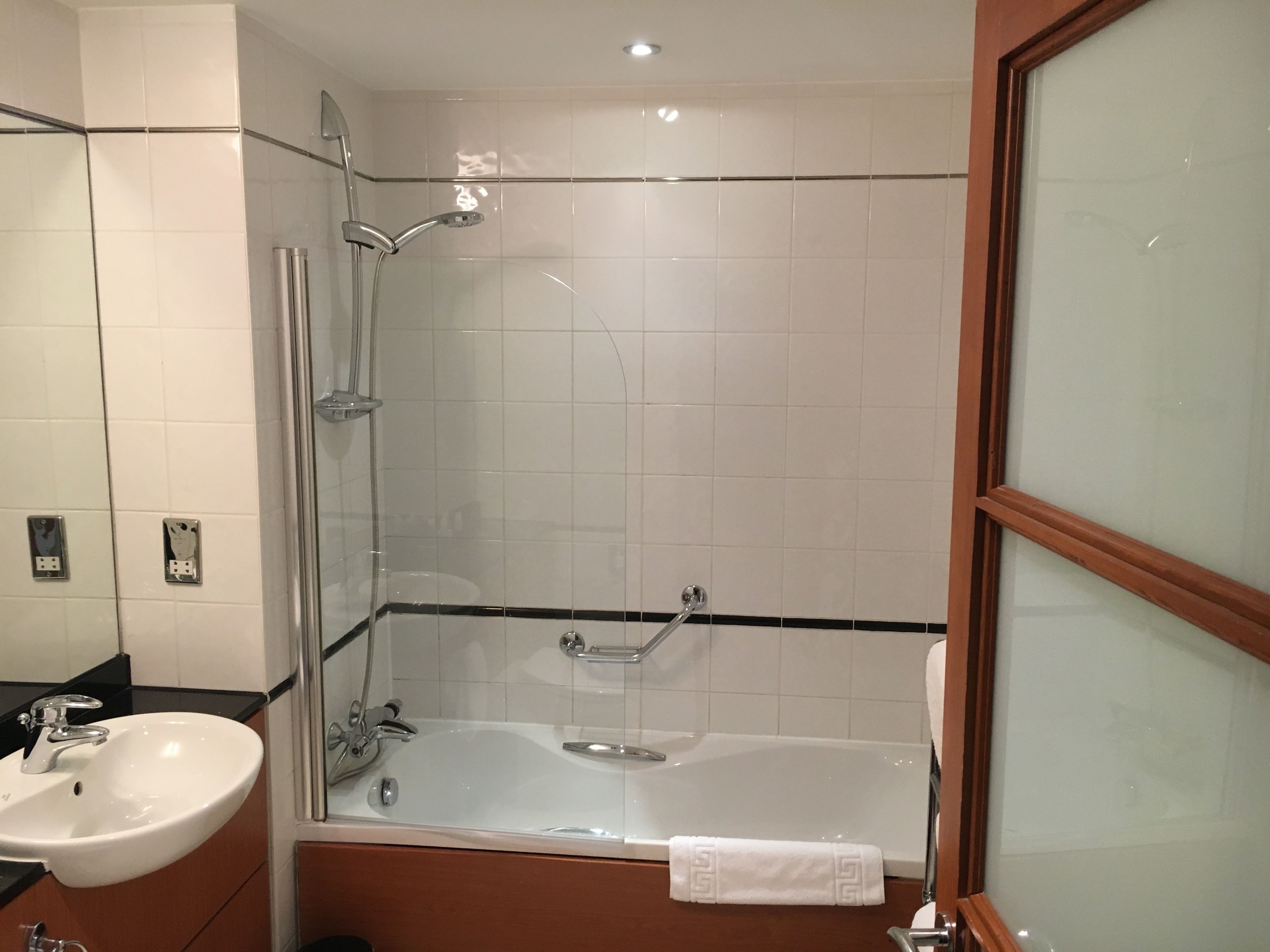 A bathroom with a glass-enclosed shower, a bathtub, and a sink.