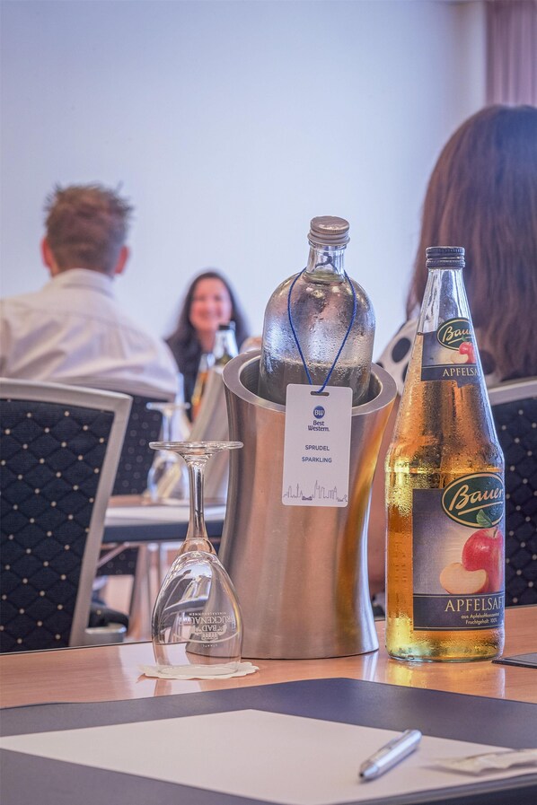 A table with a bottle of beer, a metal container, and a glass flask.