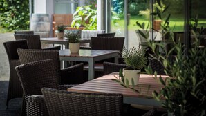 Un patio al aire libre con mobiliario de mimbre y plantas en macetas.