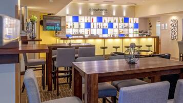 Un área de bar o sala de estar con barra, asientos y una pantalla de televisión.