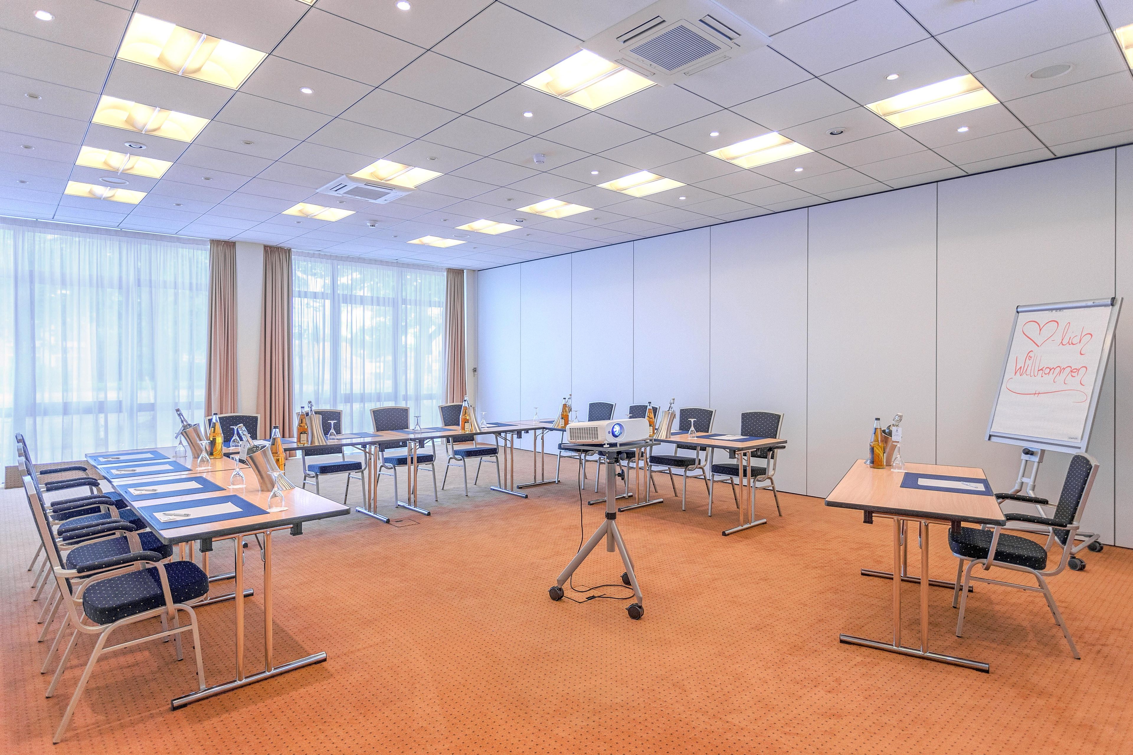 A conference room with a whiteboard, multiple tables, and chairs.