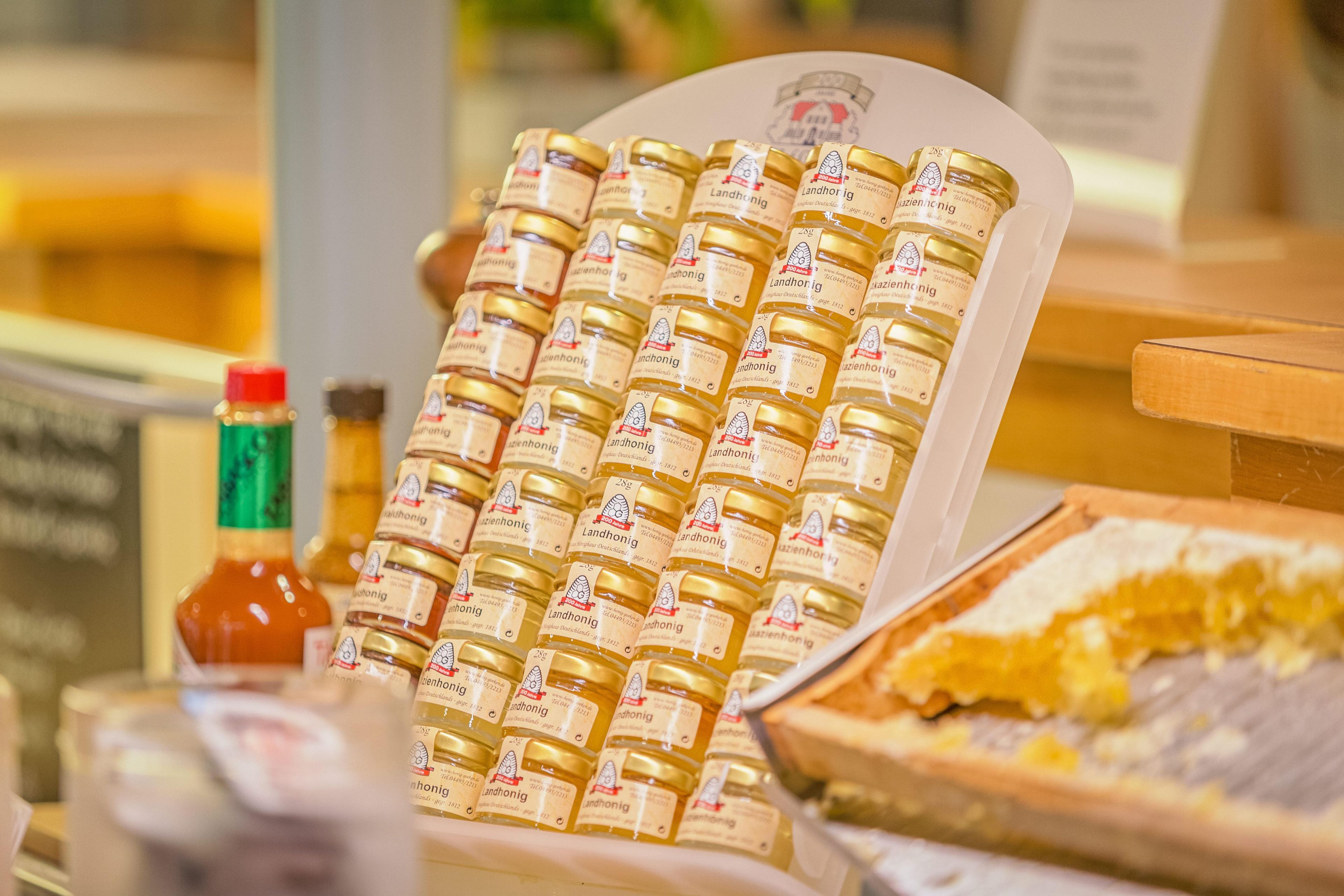 A display of honey jars with labels, a bottle of ketchup, and a box of bread.