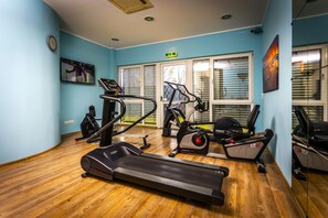 Un gimnasio con cintas de correr, bicicletas estáticas y equipo de ejercicio.