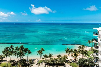 Hotel room view looking out at Aston Waikiki Beach Tower
