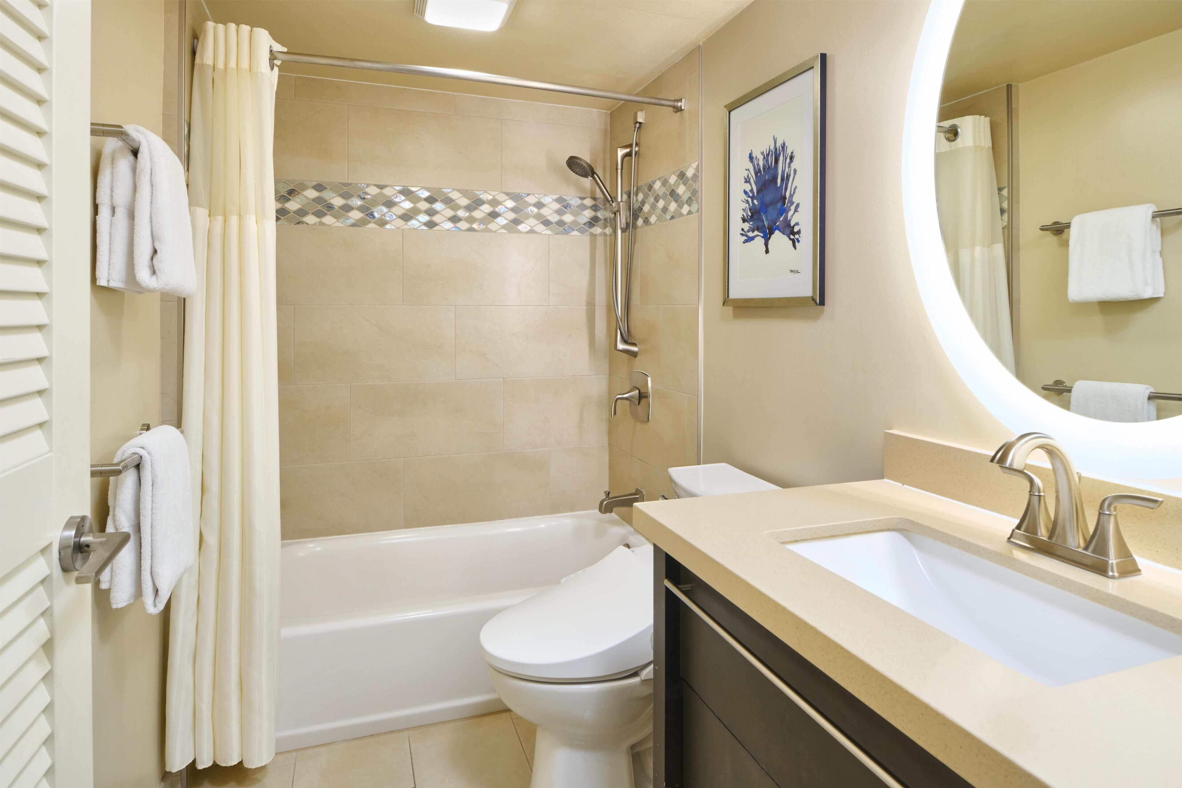 Un baño con bañera, inodoro y lavamanos.