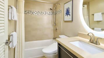 A bathroom with a bathtub, toilet, and sink.