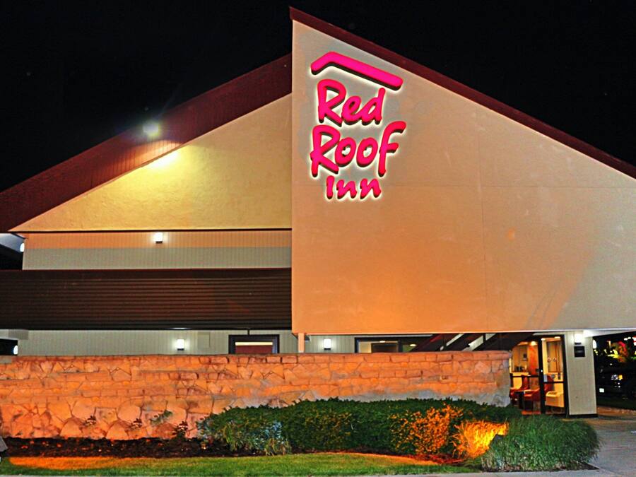 Edificio Red Roof Inn con fachada de piedra y un letrero grande iluminado.