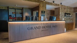 Un comptoir d’accueil en bois se trouve dans le hall du Grand Hôtel Skik, et une enseigne indique qu’il fait partie de la chaîne hôtelière Unike.