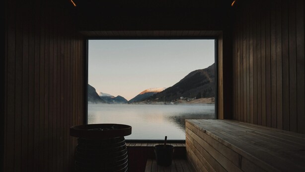 Un sauna avec vue sur un lac et des montagnes.