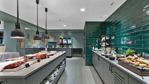 Une cuisine moderne dotée d’un long comptoir, de divers aliments et de luminaires suspendus.