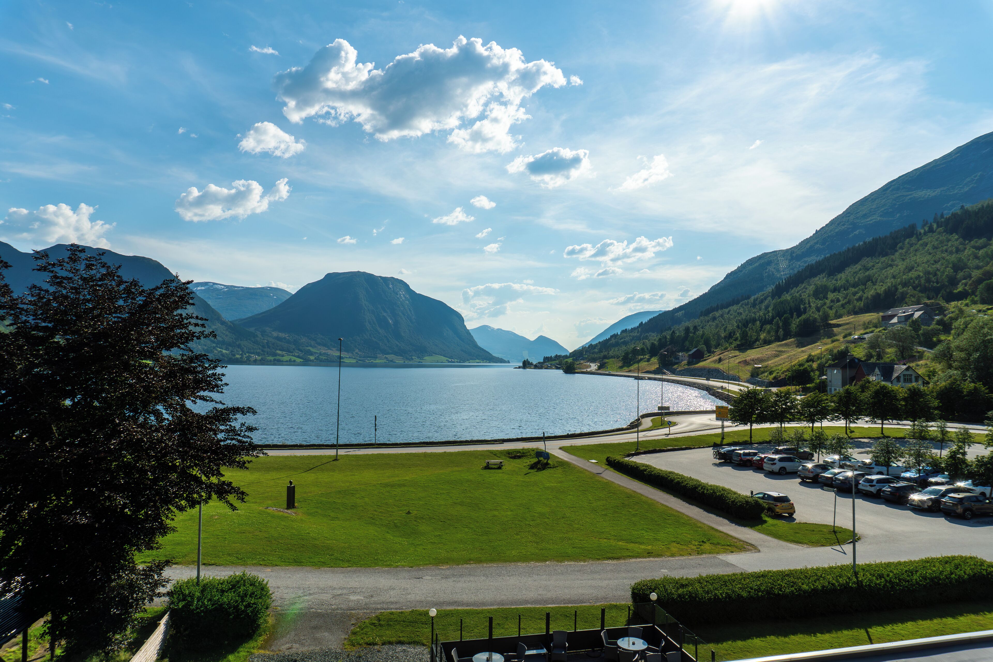 A parking area with a view of a lake and mountains.