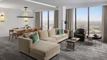 Una sala de estar moderna con un sofá modular, una mesa de comedor y un ventanal con vistas a la ciudad.