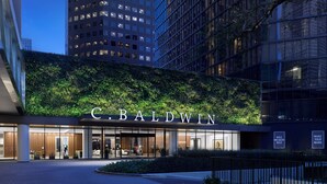 Une entrée d’hôtel moderne, agrémentée d’un mur végétal et sur laquelle le nom « C. Baldwin » est clairement affiché.