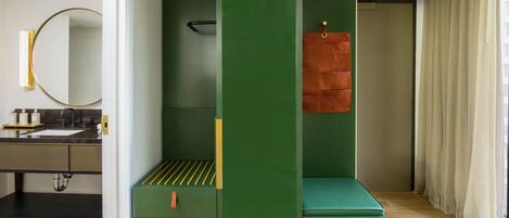 A modern bathroom with a green vanity, a mirror, and a towel rack.