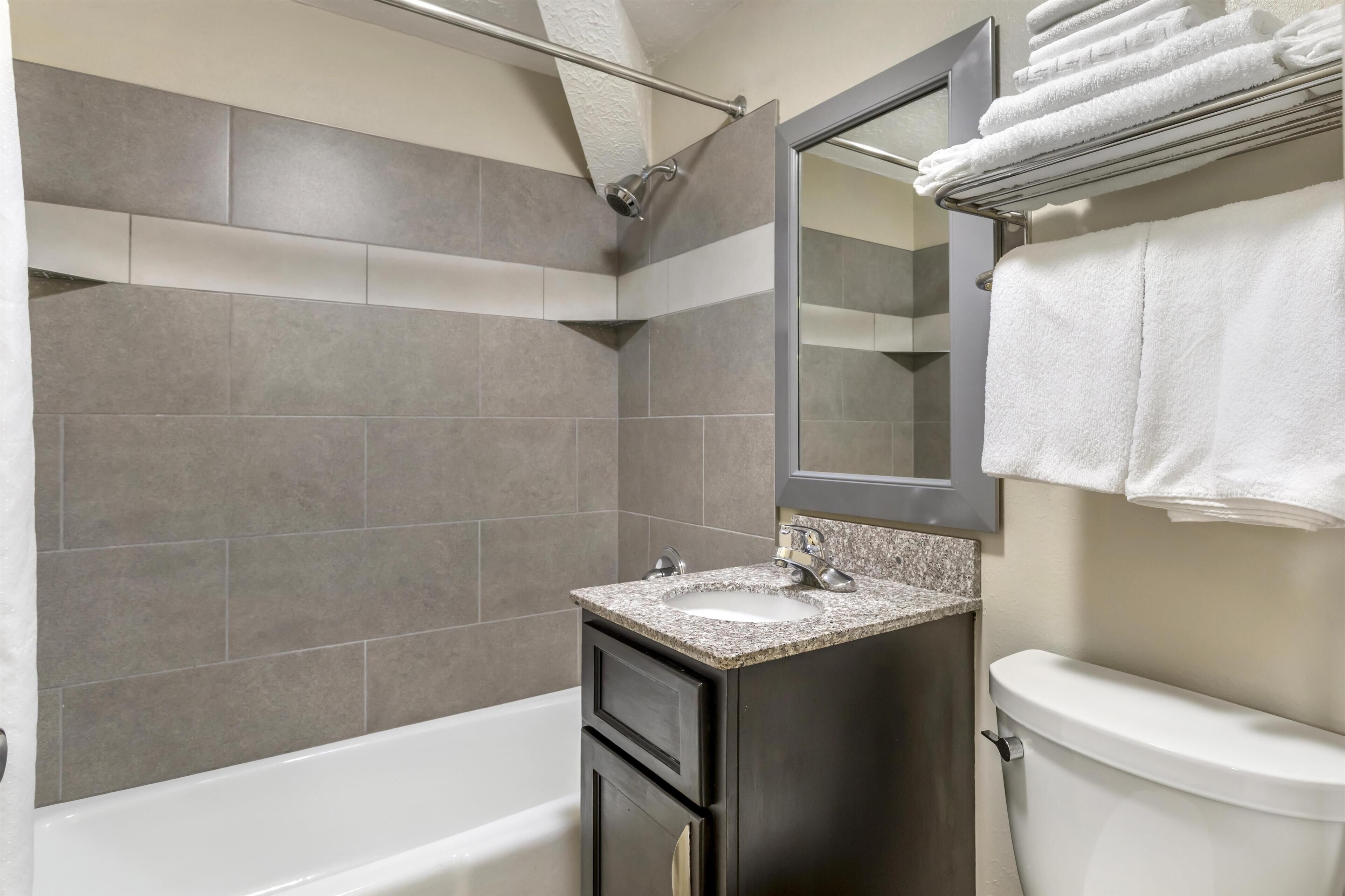 A modern bathroom with a bathtub, a sink, and a toilet.