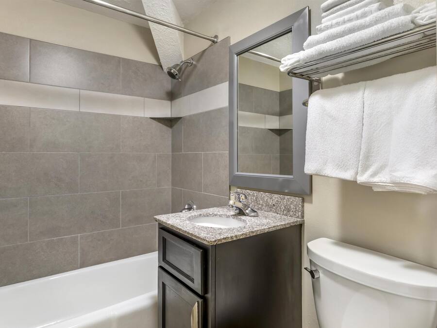 Un baño moderno con bañera, lavamanos e inodoro.