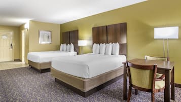 A hotel room with two beds, a desk, and a chair.